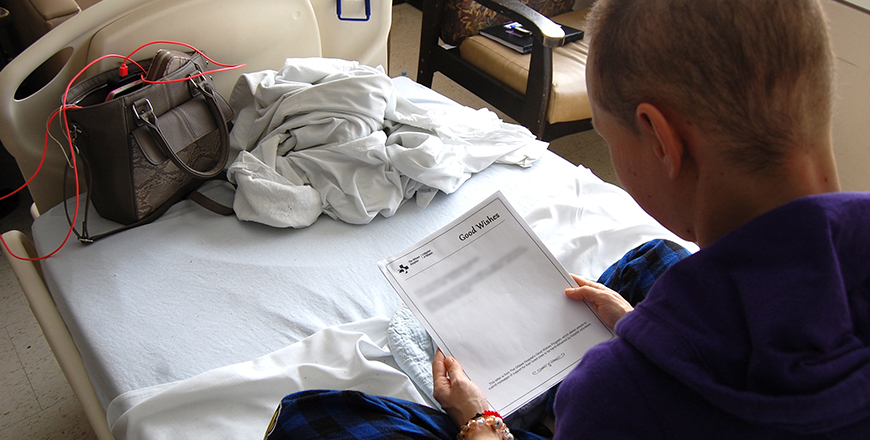 Dans son lit d’hôpital, Priscilla Kelly lit les bons vœux d’un ami.