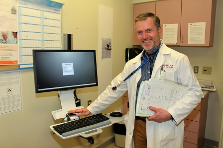 Doctor is reviewing patient's chart and test result on a computer