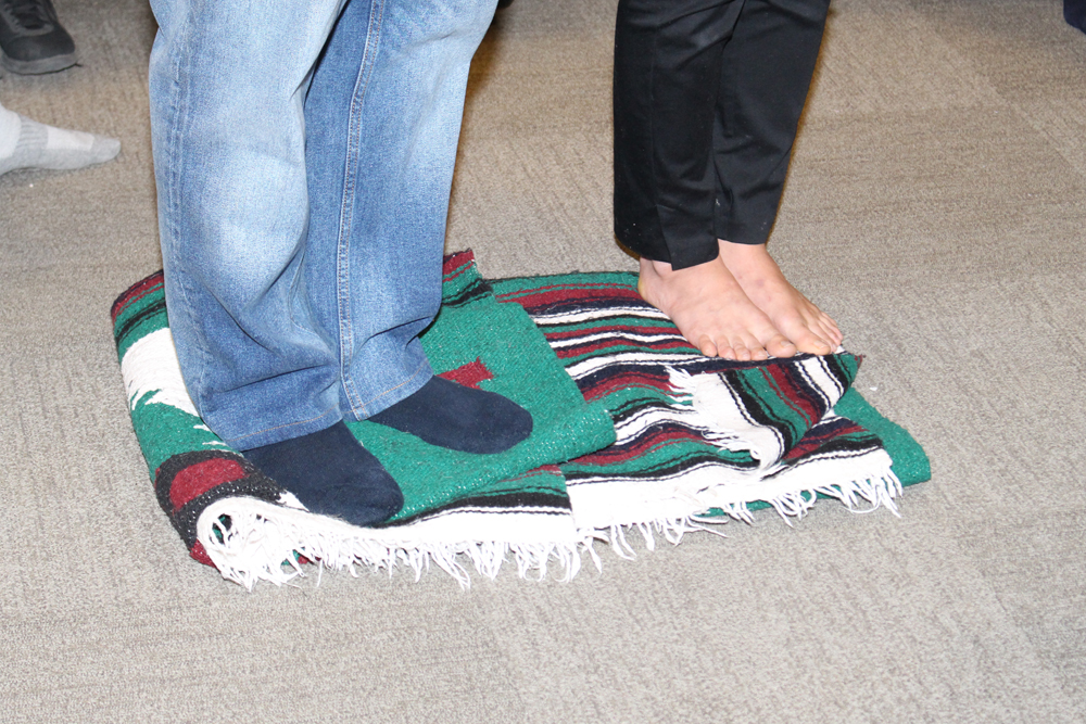 Staff members stand on blankets that represent all the land controlled by Indigenous people