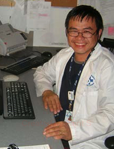 hospital employee smiling at the camera while sitting at a desk