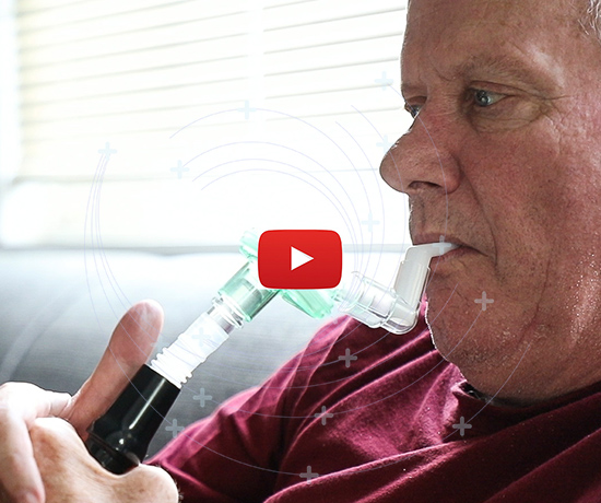 Patient Marty Meech sits on his living room couch with the CANVent apparatus between his lips