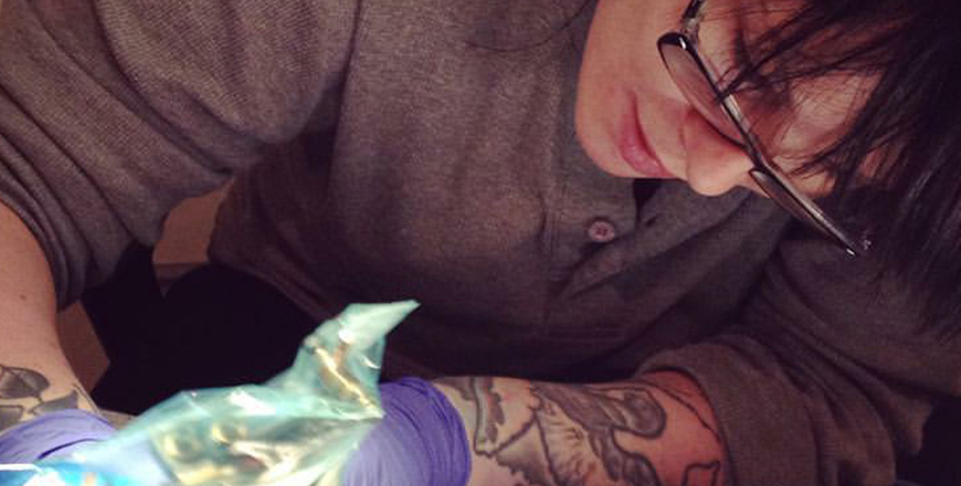 Tattoo artist Sarah Rogers works on a client's tattoo. 