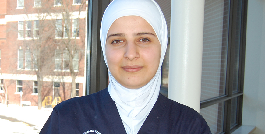 Ayse Ibrahim stands near a window at The Ottawa Hospital