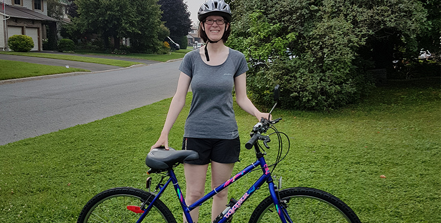 Pamela Stands holding her bike in front of her