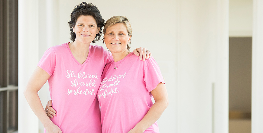 Rebecca and Mary Ellen stand side by side in a hallway