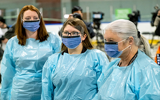 Three staff members wearing personal protective equipment
