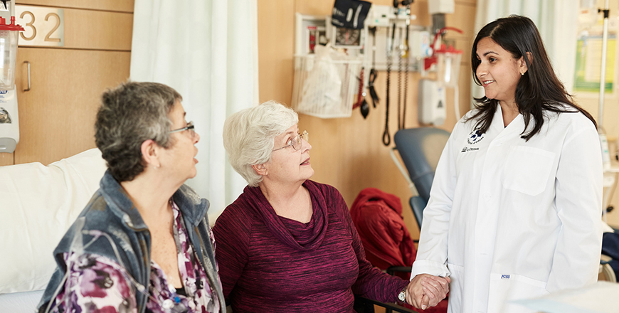 Assises, Cathy Chapman et sa sœur Enid Holohan discutent avec Saara Ali, coordonnatrice de l’essai clinique.