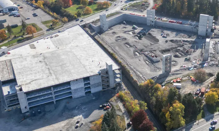 An aerial view in the fall of the partially constructed parking garage at The Ottawa Hospital’s new campus. One half of the parking garage is completed, it has multiple levels and is covered by a roof. 