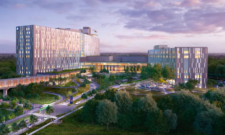 An artist rendering of The Ottawa Hospital’s new campus at dusk, showing the front exterior of the entire hospital. Trees, entry roads and vehicles are in the foreground in front of the hospital. A covered pedestrian bridge extends from the front of the building to the left and out of frame.