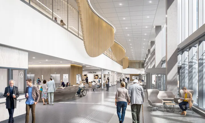 An artist rendering of the concourse inside the main entrance of The Ottawa Hospital’s new campus.  An information desk and coffee shop are on the left side of the concourse. Floor-to-ceiling windows on the right fill the space with natural light and show a clear view of the outdoors. Some people are walking throughout the scene while others are seated in various locations. 