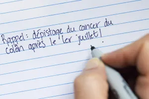 Une note manuscrite qui dit « Rappel : dépistage du cancer du côlon après le 1er Juillet! »