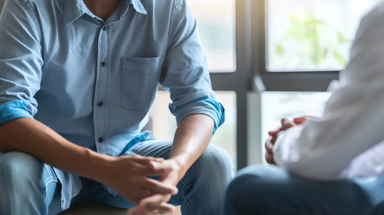 Medical professional and patient sitting down for a mental health consultation.