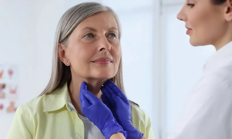 Une endocrinologue examine la glande thyroïde d’une patiente à l’hôpital.
