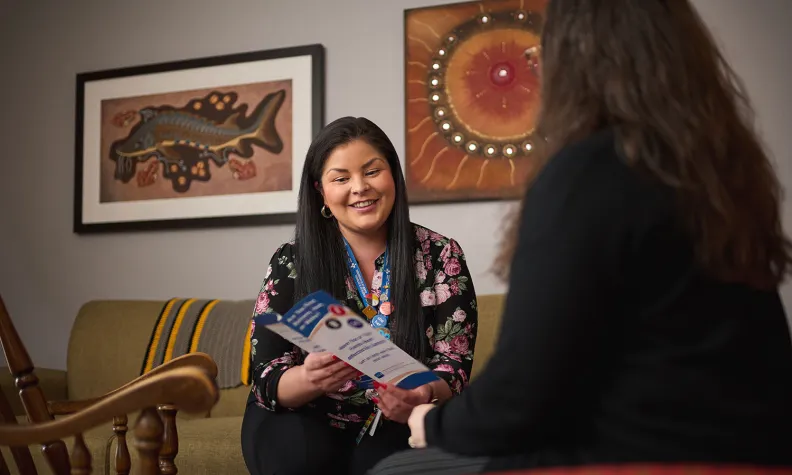 Mackenzie Daybutch (left), Program Coordinator for the Regional Indigenous Cancer Program at The Ottawa Hospital, meets with a patient (right) in the Windòcàge Community Room.  