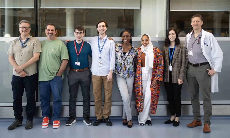 A group of Hepatitis program staff stand side by side in a bright indoor space.