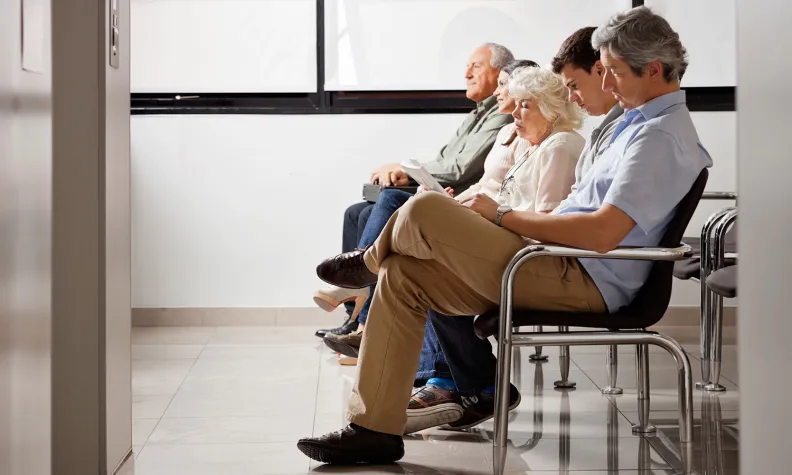 People sitting in chairs in a waiting room.