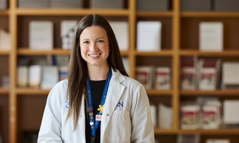 Nurse navigator standing at a reception desk in a clinical setting.