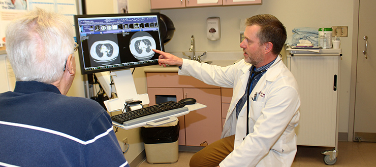 Medical oncologist Dr. Neil Reaume is showing his patient John Richichi, the results of his medical imaging tests right in the exam room