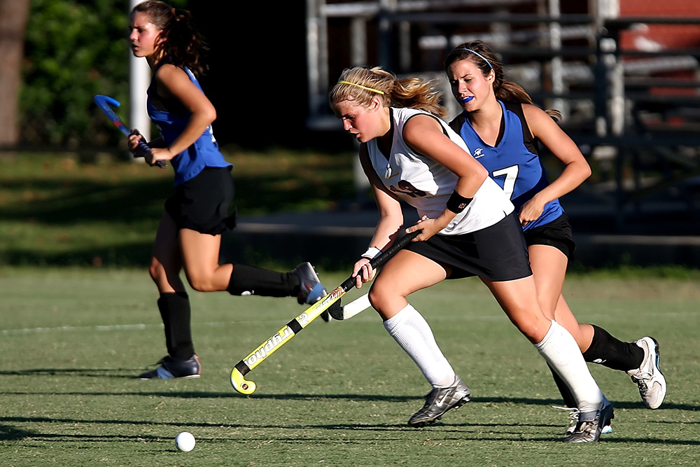 Women are playing field hockey