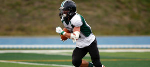 A football player is running in the ground