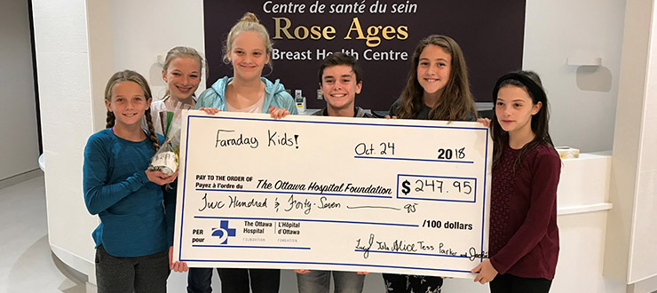 six 11-year-olds holding a giant cheque