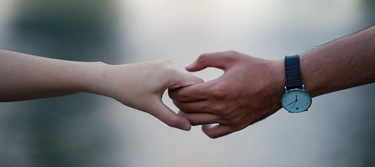 A male and a female hands holding each others