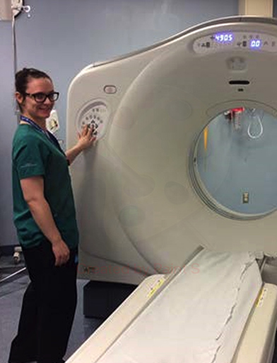 a technologist manipulating a CT scanner
