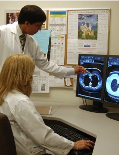 three hospital employees observing a scan on a computer