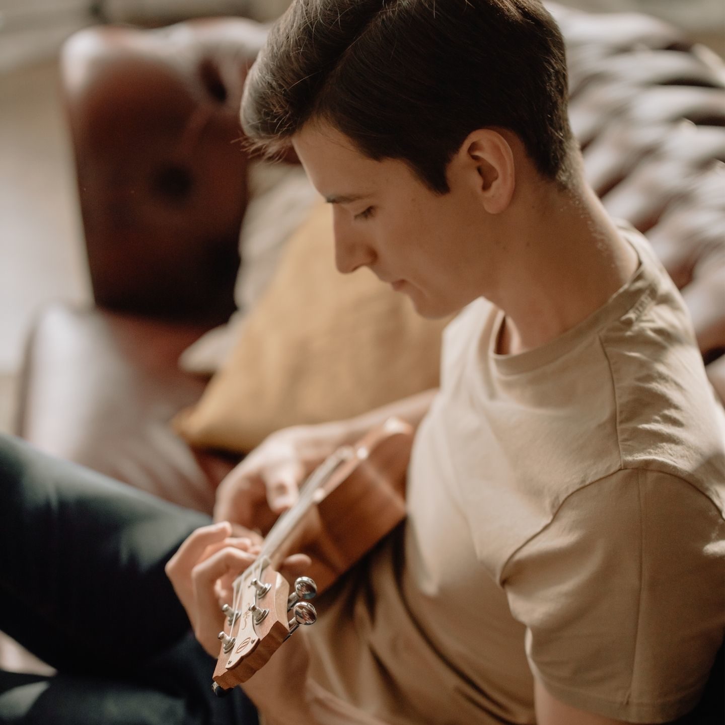 A man sitting on a couch playing a guitar