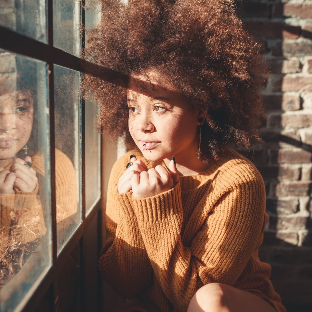 Une femme regarde par la fenêtre.