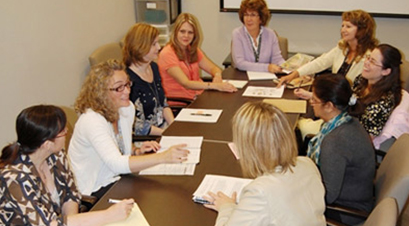 a group of staff members sitting together and discussing about the program