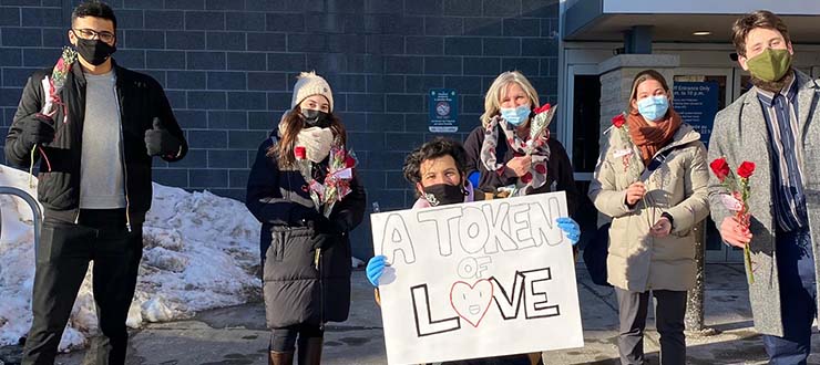 Students and hospital staff with roses.