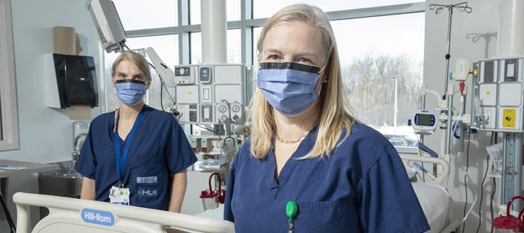Irene Watpool and Rebecca Porteous standing near an empty bed in the ICU