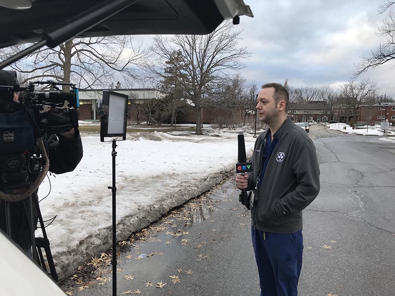 Le Dr Andrew Willmore tient un microphone de CTV à l’extérieur du Centre d’évaluation pour la COVID-19 de l’aréna Brewer.