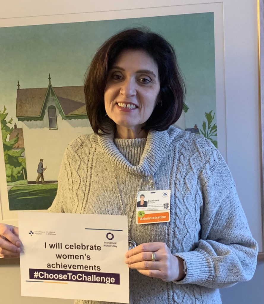 Suzanne Madore tenant une affiche de la campagne de 2021