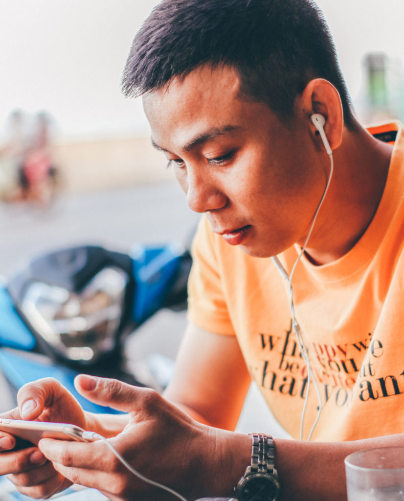 Man using earphones attached to his cell phone