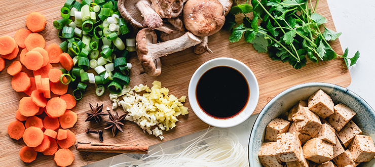 Une alimentation à base de plantes : carottes, oignon vert, anis étoilé, ail, champignons, coriandre fraîche et tofu