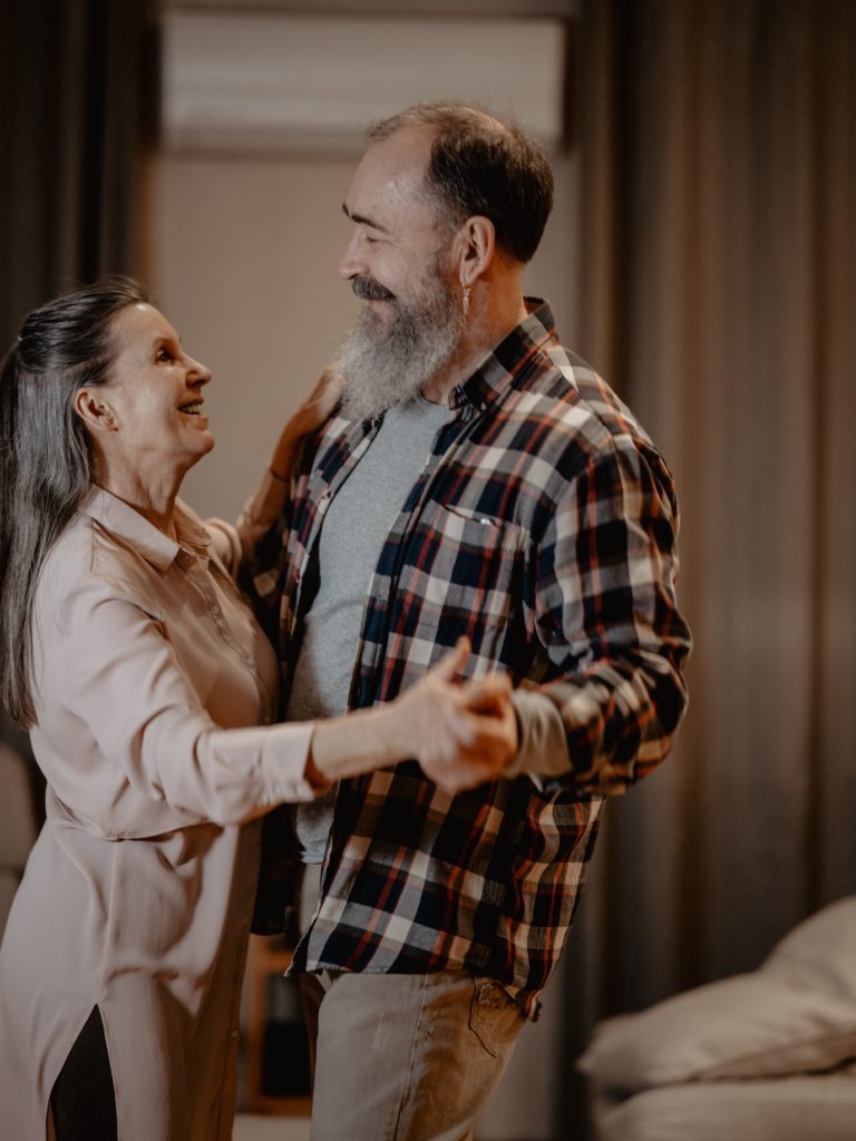 Un homme et une femme âgés dansent près l’un de l’autre.