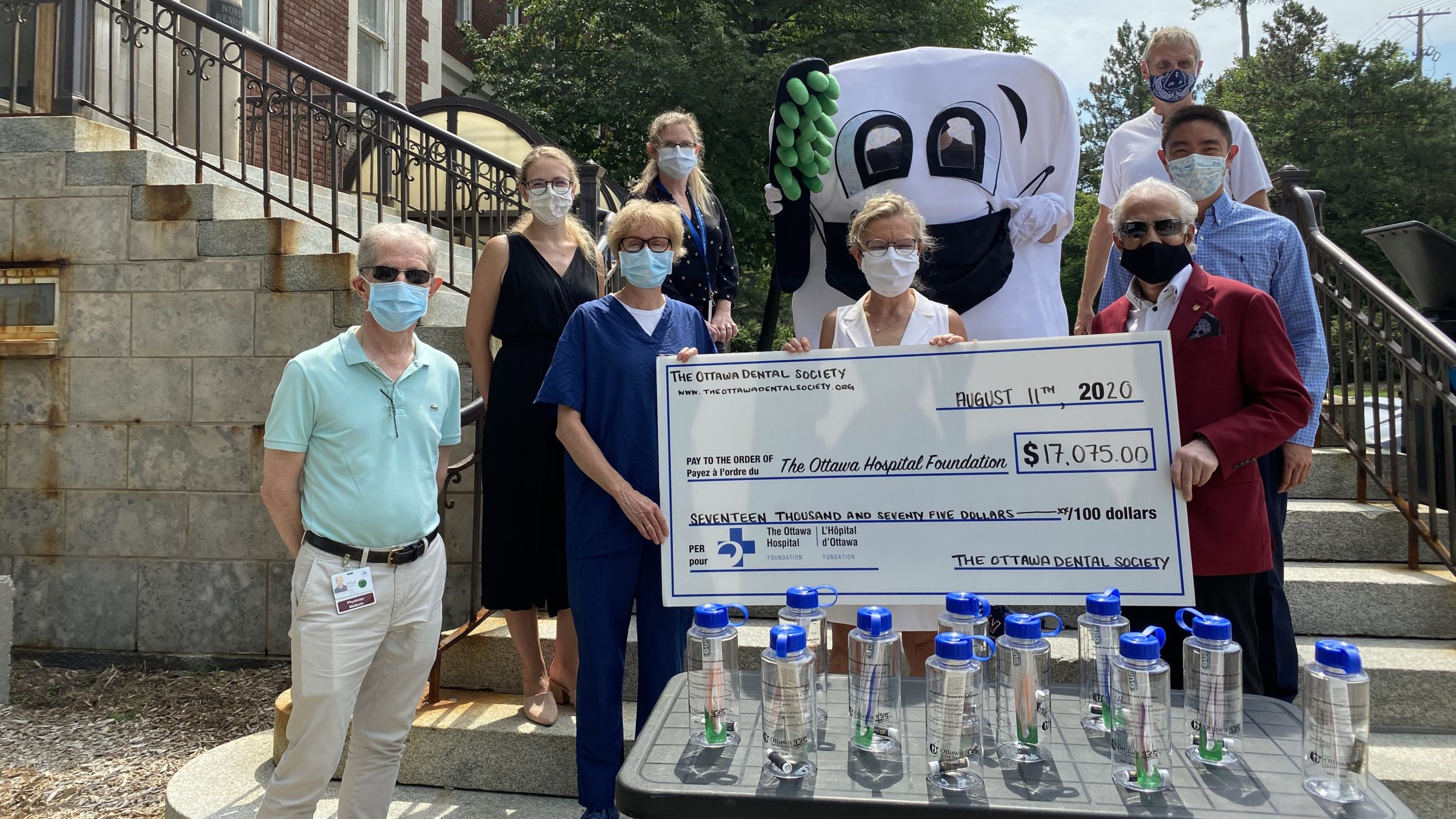 Dental Clinic staff hold a large cheque.