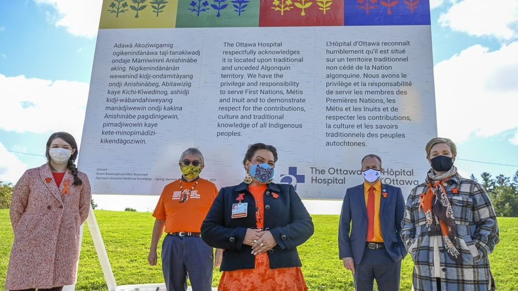 From left to right: Mairi Brascoupé, Simon Brascoupé, Marion Crowe, Cameron Love, Katherine Cotton standing in front of the land acknowledgement sign.