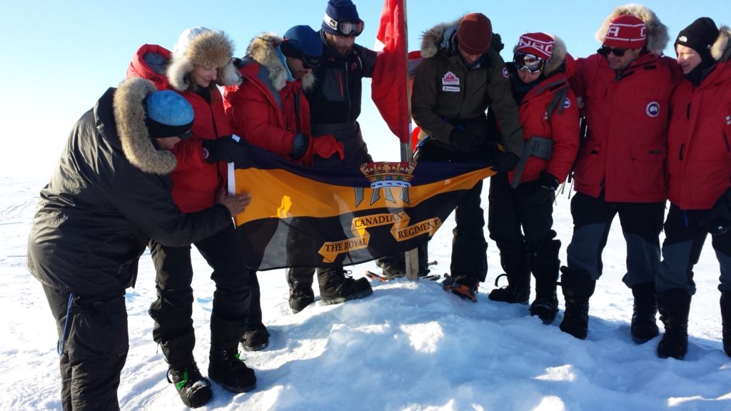 Le groupe de skieurs tient un drapeau.