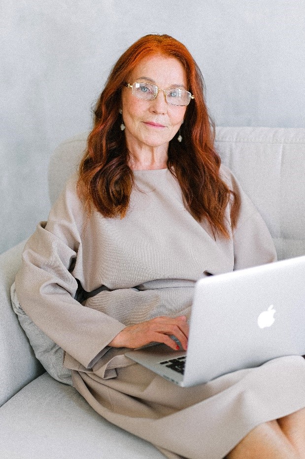 Older woman wearing glasses and using a computer