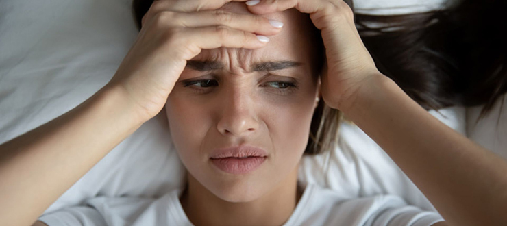 Woman feeling stressed in bed.