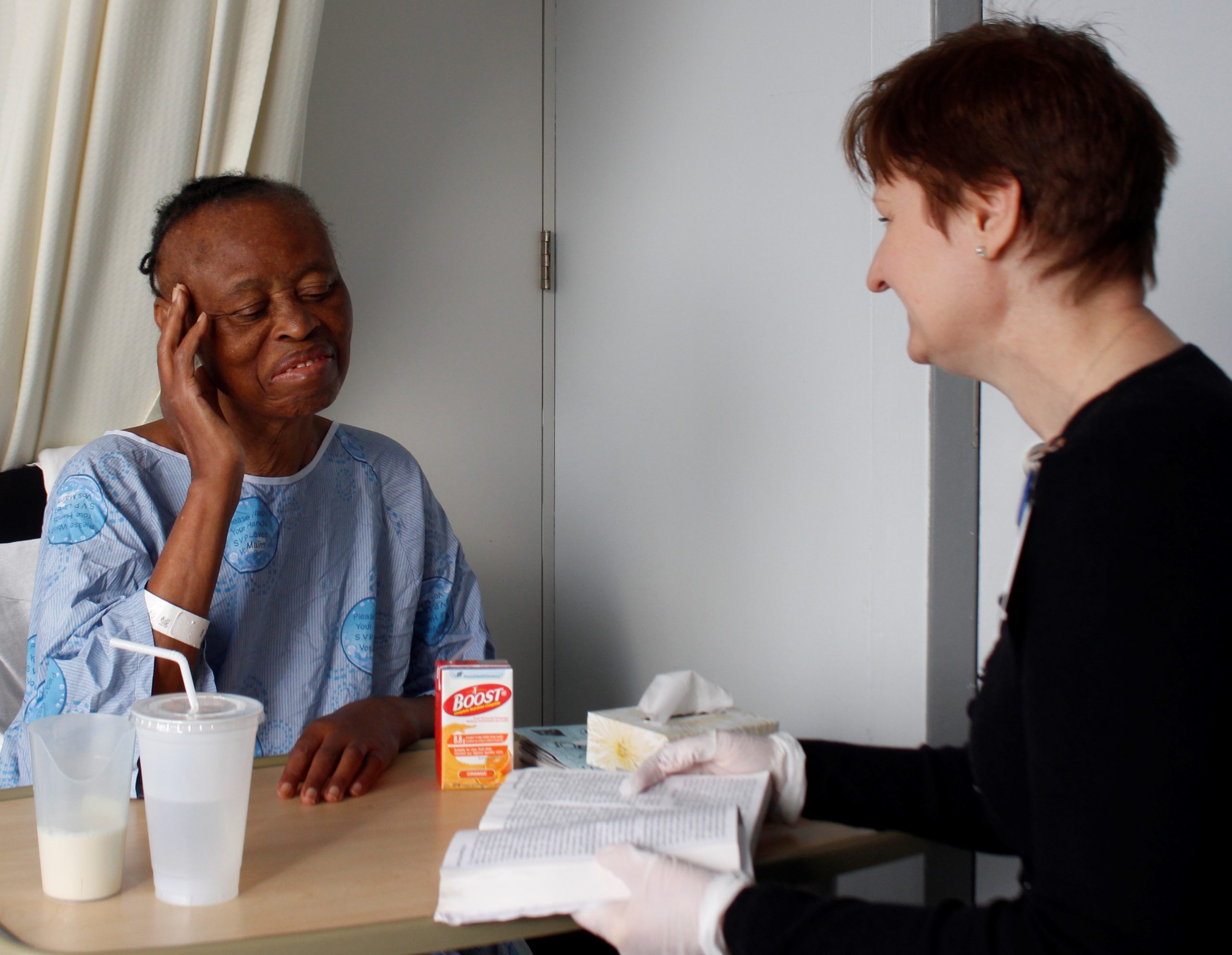 Intervenante en soins spirituels lit un livre à un patient