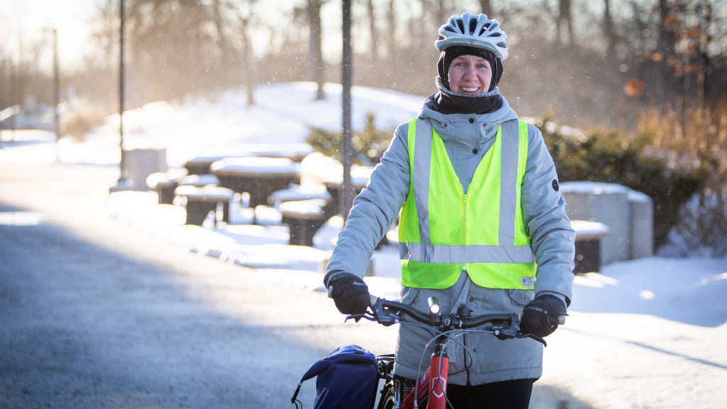 Dr. Eugenie Waters wearing winter clothing and holding her bike