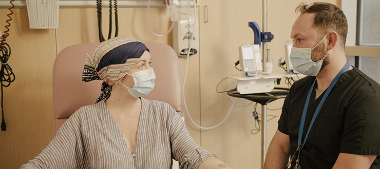 A patient sitting in a chair talk to her health-care provider