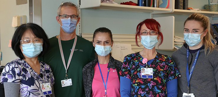 A group of five nurses wearing face masks