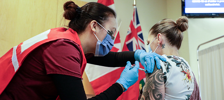 Nurse Venus Lucero administers the COVID-19 vaccine to Jo-Anne Miner