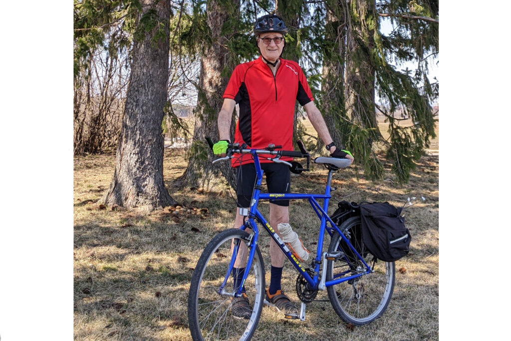 Don stands behind his bicycle in a forest