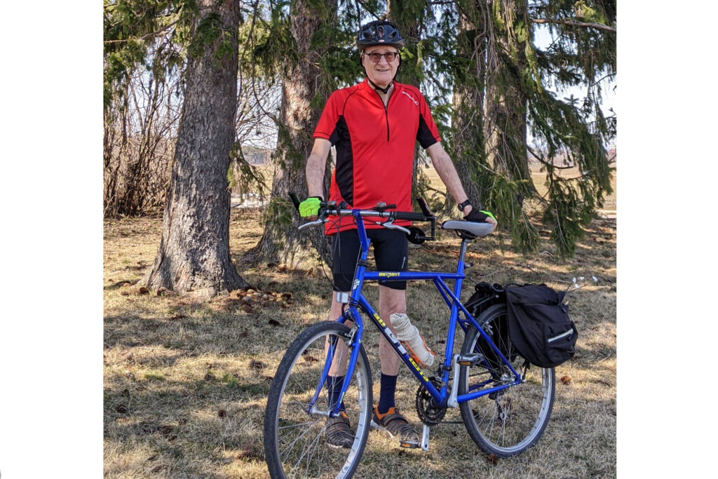 Don debout avec son vélo dans une forêt